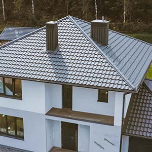 Metal Roofing Systems - click to learn more about Metal Roofing Systems available styles and warranties - House with dark gray metal shingles